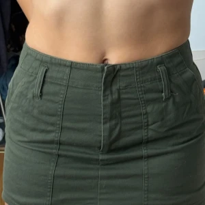  minikjol med fickor - Militärgrön kjol med fickor fram 