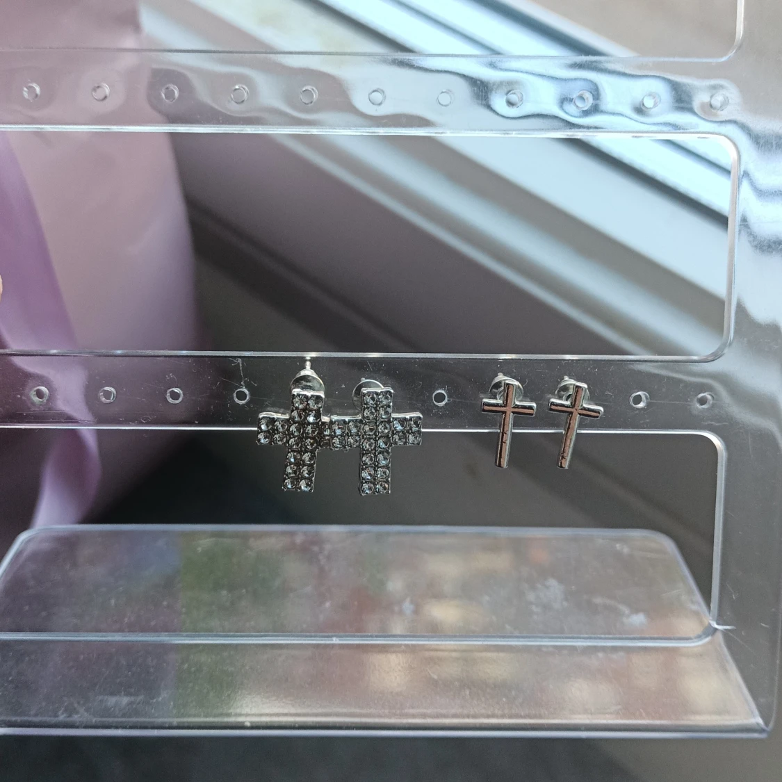 Två par korsformade örhängen i silverfärg