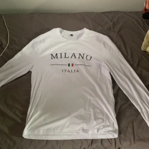 Vit långärmad Milano-tröja - Säljer en vit långärmad tröja MILANO ITALIA Tröjan har rund halsringning och är i ett mjukt material, perfekt för en stilren vardagslook.
