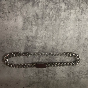 Silver armband - Säljer ett set med ett armband i silver armbandet har en kraftig kedja på ena sidan och en tunnare länk på andra sidan samt en rektangulär platta i mitten. Perfekt för dig som gillar stilrena accessoarer.