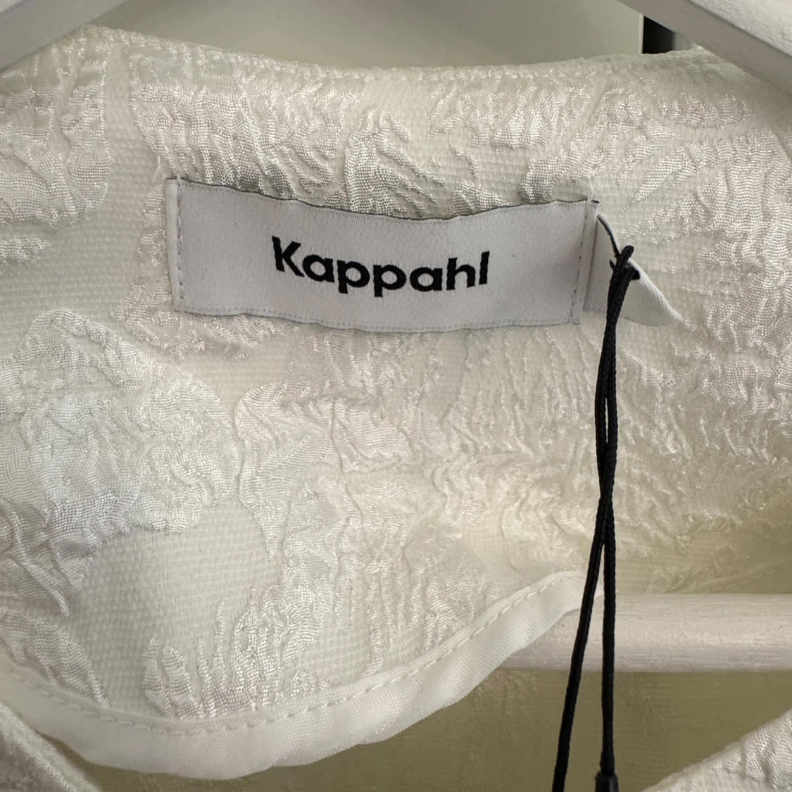 Vit blus/kofta med svarta rosetter från Kappahl - 2