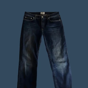 Mörkblå jeans från Acne Studios - Snygga mörkblå jeans från Acne Studios med klassisk femficksdesign och knappgylf. Perfekta för en stilren look.