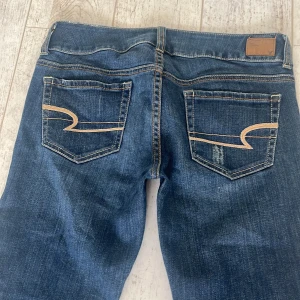 Lågmidjade bootcut jeans - Superfina lågmidjade jeans från American Eagle. Midjemått 39+stretch och innerbenslängd 76