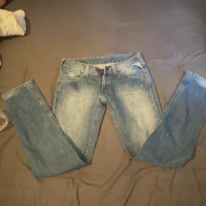 Replay jeans  - Säljer ett par blå Replay jeans med snygga slitningar och orange detaljer vid bakfickan. Klassisk femficksmodell med raka ben och läderpatch med Replay-logga bak. Perfekta för dig som gillar en tidlös jeanslook. Dom har lite mindre fickor. Skriv via minste lilla fundering och kan gå ner i pris vid  snabb affär 