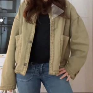 Grön oversized jeansjacka - Säljer en beige oversized jeansjacka med stora fickor framtill och knäppning. Jackan har lång ärm och en avslappnad passform, perfekt att slänga över en t-shirt eller hoodie.