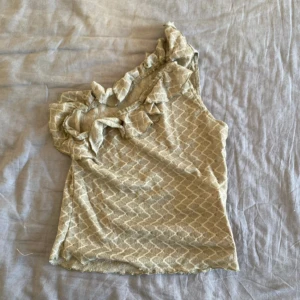 Oneshoulder topp med volang - Så söt oneshoulder topp, skickar samma dag eller dagen efter!💓 säljer liknande plagg så kolla gärna in min profil💞💞(färgen på toppen är khaki)