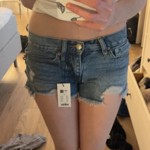Blå jeansshorts med fransar - Säljer ett par blå jeansshorts från Lager 157 i storlek XXS. Lappen är kvar då shortsen är helt nya och aldrig använda! Säljer även samma shorts fast i ljusblå ❣️