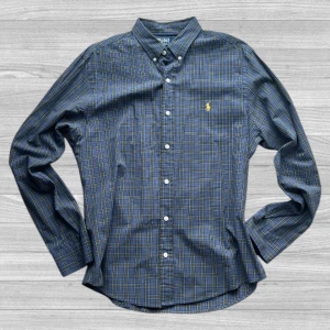 Ralph Lauren - Säljer en blårutig skjorta från Polo Ralph Lauren i slim fit. Skjortan har klassisk krage, knappar framtill och den ikoniska gula broderade loggan på bröstet. Perfekt för dig som gillar stilrena och tidlösa plagg.