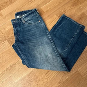 Blåa jeans Arrow från Weekday - Säljer ett par klassiska blåa jeans från Weekday, modellen Arrow. Jeansen har raka ben och normal passform med hög midja. Tillverkade i bomull och har en snygg tvättad look med ljusare partier framtill.