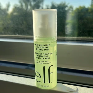 e.l.f. Stay All Night Micro-Fine Setting Mist - Makeup setting mist från e.l.f. i en ljusgrön plastflaska med vit spraykork. Ger en micro-fin mist som håller sminket på plats upp till 16 timmar. Perfekt för att fräscha upp och fixera din makeup under dagen.