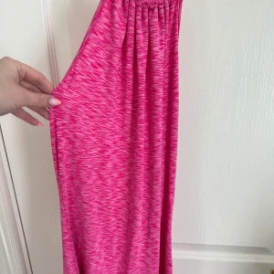 Rosa klänning - Säljer en rosa klänning som man knyter i nacken. Den är djup i ryggen och är tillverkad i ett mjukt, stretchigt material🩷