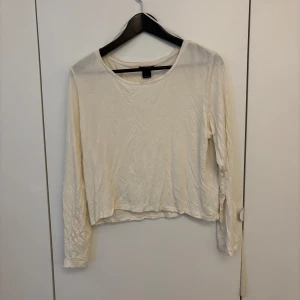 Vit långärmad topp från Lindex - Säljer en enkel och stilren vit långärmad topp från Lindex. Modellen är croppad med rund halsringning och tillverkad i ett mjukt bomullsmaterial.