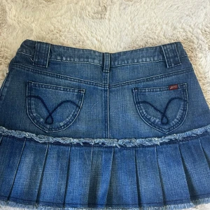 Jeanskjol med volang - Säljer en blå jeanskjol från Oasis Jeans med volanger. Midjemåttet: 38 cm och Längden: 35 cm. Fortfarande prislappen kvar!