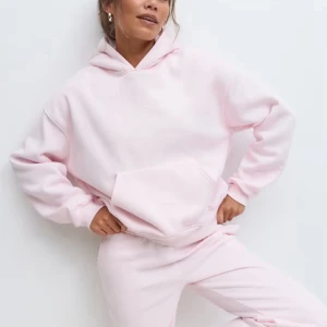 Ljusrosa mjukisett  - Supermysig ljusrosa hoodie med stor magficka och huva, med snygga raka byxor till.Tröjan har en loose passform och långa ärmar, perfekt för chill dagar. Mjuk fleece på insidan gör den extra skön att bära. Enkel och stilren design utan tryck eller mönster.