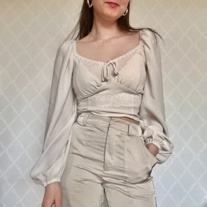 Vit topp  - Fin topp med långa puffärmar och knyt framtill. Går säkert att styla bättre än vad jag gjort på bilden då den är ganska genomskinlig…🙈🥰