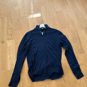 Mörkblå half zip tröja Jack & Jones XS - Mörkblå långärmad tröja från Jack & Jones i storlek XS. Tröjan har en stilren half zip-dragkedja vid halsen och ribbade muddar vid ärmslut och nederkant. Perfekt för lager-på-lager och snygg till jeans eller chinos. Köpt för 500kr mitt pris 199kr.