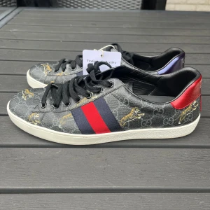 Gucci ace skor tiger - Säljer dessa sjukt eftertraktade och sällsynta Gucci ace skorna med tiger design. Skorna är i väldigt bra skick som ni kan se på bilderna och verifierad äkta av Vestiaire Collective. Tagen medföljer vid köp. Storlek UK8 ~ 42/43. Inget annat OG