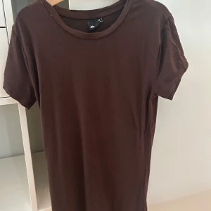 Brun t-shirt från Gina Tricot XS - En basic brun t-shirt från Gina Tricot i storlek XS. Modellen är klassisk med rund hals och korta ärmar. T-shirten är gjord i mjuk bomull och har en normal passform som funkar till många olika stilar.