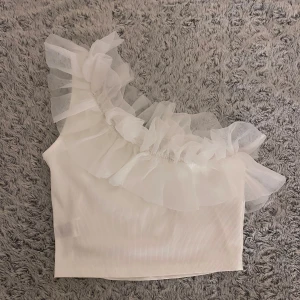 Vit oneshoulder topp med volang - Jättefin vit topp som aldrig är använd🤗🤗