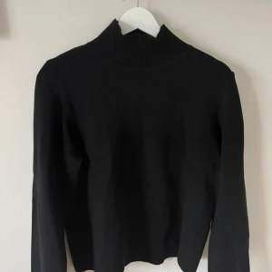 Svart polotröja från Object - Svart polotröja från Object i storlek S. Tröjan har en hög, ribbad krage och är långärmad. Enkel och stilren design som passar perfekt till jeans eller kjol. Materialet känns mjukt och bekvämt mot huden.