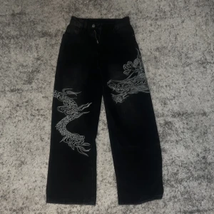 Svarta jeans med drakmönster - Helt nya jeans aldrig använda. Vet inte vart de är ifrån men de passar mig inte längre.