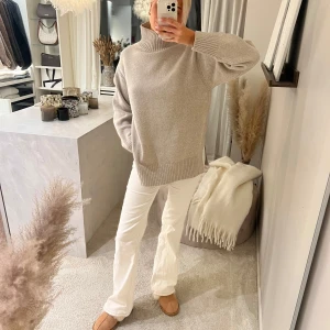 Beige stickad polotröja från H&M  - Säljer en beige polotröja i stickad med oversized passform. Tröjan har höga ribbade muddar vid ärmslut och nederkant samt en rejäl polokrage. Perfekt för lager-på-lager och chill höst- och vinterstil.