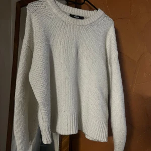 Vit stickad tröja från Bik Bok - Mysig vit stickad tröja från Bik Bok med rund halsringning och breda ribbade muddar vid ärmslut och nederkant. Tröjan har en relaxed passform och långa ärmar så perfekt för lager på lager. 