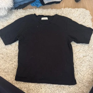 Svart t-shirt från Lindex XS - En enkel svart t-shirt från Lindex i storlek XS. Modellen har rund hals och gjord i mjuk bomull. Passformen är normal och funkar till de flesta outfits.