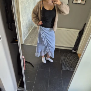 Blå omlottkjol med volang från Vero Moda - Supersöt lång omlottkjol från Vero Moda i ljusblått med små vita och gula blommor❣️passar mig dom har S