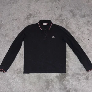  pikétröja Moncler - Snygg svart långärmad pikétröja från Moncler.