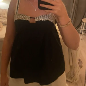 Assnygg topp från Zara, festtopp🦄💕 - Supersnygg svart topp från Zara med glittriga strassdetaljer. Jag har sytt upp banden på båda sidorna men det går att ta bort tråden lätt❤️har alltså ej klippt i banden!! Säljer då den inte kommer till användning 🦄🦄🦄passar XS/S