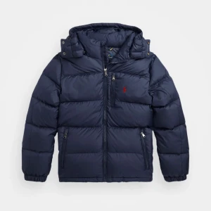 Ralph lauren jacka - Snygg mörkblå pufferjacka från Polo Ralph Lauren med huva och dragkedjor. Köptes 2023 och har typ använts 5 gånger. I storlek M och köpt på man avdelningen men den passar för kvinnor oxå. Den är lite oversized därav varför den är köpt i M💕