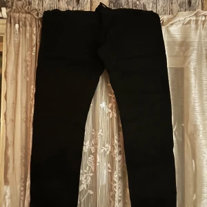 Svarta raka byxor från lee  - Säljer ett par svarta byxor med rak passform. De är stilrena och passar perfekt till dig som gillar en klassisk look. Materialet känns mjukt och bekvämt, och färgen är heltäckande svart.