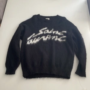 Svart stickad Saint Laurent tröja - Säljer en svart stickad tröja från saint Laurent Materialet är fluffigt och mjukt, köpt på Vinted