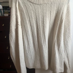 Ribbad beige stickad tröja gina tricot - Säljer en mysig beige stickad tröja från Weekday med ribbad struktur och rund hals. Tröjan har lång ärm och är perfekt för dig som gillar enkel och clean stil. Materialet är mjukt och ger en chill vibe till outfiten.