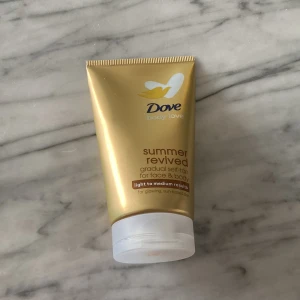 Dove Summer Revived Self-Tan 75ml - Dove Summer Revived gradual self-tan för ansikte och kropp, 75 ml. Ger en lätt till medium solkysst ton med naturlig glow. Innehåller aloe vera och glycerin för återfuktning. Guldig tub med vit flip-top kork, perfekt att ha med i väskan. Oöppnad och aldrig använd☺️