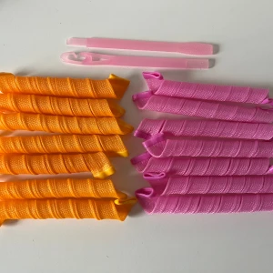 Hårspolar/heatless curles  - Säljer ett set med hårspolar i orange och rosa plast, perfekta för att skapa snygga lockar utan värme. 