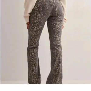 Leopardmönstrade bootcut jeans - Snygga bootcut jeans med leopardmönster i grå och beige toner. Byxorna har klassisk femficksdesign och normal passform. Perfekta för dig som vill sticka ut med ett djurmönster och ändå ha en bekväm jeanslook. Uppsydda ungefär 7cm, passar mig perfekt som är 164cm!