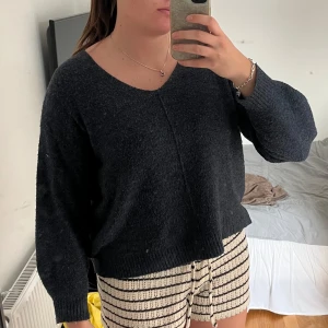 Mörkblå stickad tröja med v-ringning - Säljer en mysig mörkblå stickad tröja med v-ringad hals och långa ärmar. Tröjan har en loose passform och ribbade muddar vid ärmslut och nederkant. Perfekt för dig som gillar enkel och chill stil. Den har använts en del men har fortfarande bra kvalitet!