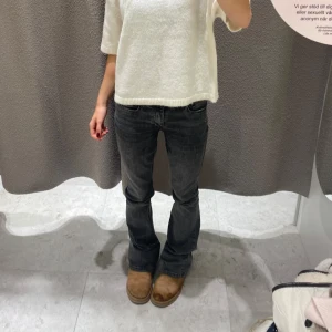 Grå bootcut jeans med låg midja - Säljer ett par grå jeans med bootcut-modell och låg midja. Jeansen har klassisk femficksdesign och är i ett mjukt denimtyg. Snygg tvättad grå färg som passar till allt och ger en cool vibe.