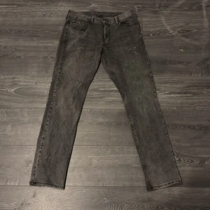 Levi's 511 svarta jeans W33 L34 - Säljer ett par svarta Levi's 511 jeans i slim fit med klassisk femficksdesign. Jeansen har en snygg tvättad look och är tillverkade i bomull. Har en liten fläck på vänster lår men de inget som syns speciellt mycket