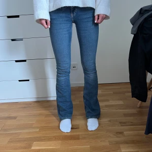 Blå bootcut jeans med stretch - Snygga blå jeans med bootcut passform och klassisk femficksdesign. Jeansen har en smal passform upptill och lätt utsvängda ben, vilket ger en riktigt schysst siluett. Tillverkade i stretchigt denim för extra komfort. Perfekta till sneakers eller boots.