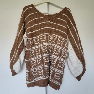 Brun och vit virkad tröja med björnar - Hemvirkad tjocktröja med ränder och björnar. Tröjan har v-ringning framtid, långa ärmar och är oversized. Jag har normalt strl S men den väldigt oversized på mig och skulle utan problem passa strl M också. Eftersom den är hemmavirkad har den små "fel" som trådar etc (se bilder för exempel). Tröjan måste handtvättas och torka liggandes. 
