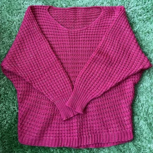 Glittrig rosa stickad tröja - Säljer en rosa stickad tröja med glittriga inslag. Tröjan har en loose passform, rund halsringning och långa ärmar med ribbade muddar. Perfekt för dig som vill ha något färgstarkt och mysigt med lite extra bling.