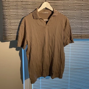 Beige piké från Zara i bomull - Säljer en stilren beige pikétröja från Zara i storlek S. T-shirten har klassisk krage och korta ärmar, perfekt för en clean och enkel look. Tillverkad i mjuk bomull som känns skön mot huden.