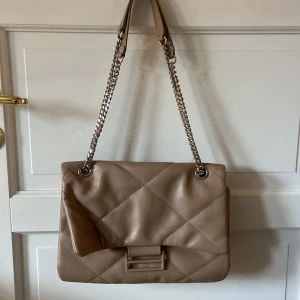 Beige väska - Säljer en beige axelväska med kedjerem i bra skick. 