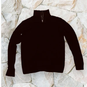 Svart half zip tröja Jack & Jones - Svart långärmad tröja från Jack & Jones med hög krage och half zip-dragkedja. Perfekt för lager-på-lager och enkel att matcha med jeans eller chinos. Mjuk och skön, passar till både chill och skola. Storlek S och asskön 