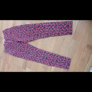 Rosa leopardmönstrade jeans Zara - Snygga jeans från Zara i rosa med svart leopardmönster. Klassisk femficksmodell med normal passform och raka ben. Perfekta för dig som vill sticka ut med ett djuriskt print. Tillverkade i bomull för skön känsla hela dagen.