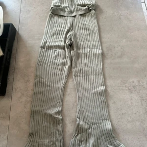 Ribbade vida byxor från H&M - Snygga ribbade byxor från H&M i ljusbeige färg. De har hög midja, vida ben och är stickade i mjukt material. Perfekta för en chill och trendig look. Elastisk midja för extra komfort.