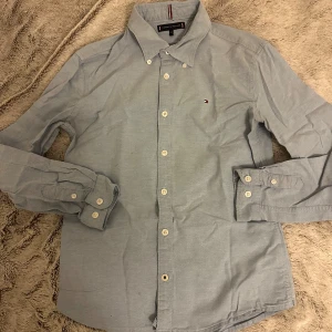 Ljusblå skjorta från Tommy Hilfiger - Snygg ljusblå skjorta från Tommy Hilfiger i bra skick. Storlek 152, pris kan diskuteras!